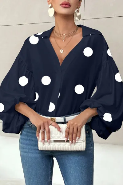 Polka dot, loose-fitting, puff-sleeved top with a semi-open collar.